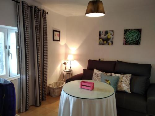 a living room with a table in front of a couch at An'Ca' La Pura in Villanueva del Conde