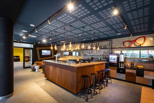 un bar dans un restaurant avec des tabourets de bar dans l'établissement Hostel Le Hüb Grenoble, à Grenoble