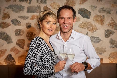 a man and a woman holding glasses of white wine at Rainerhof in Flachau