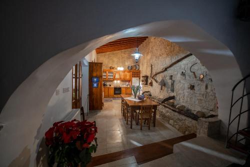 een keuken en eetkamer met een stenen muur bij Apanemia Inn House in Lofou
