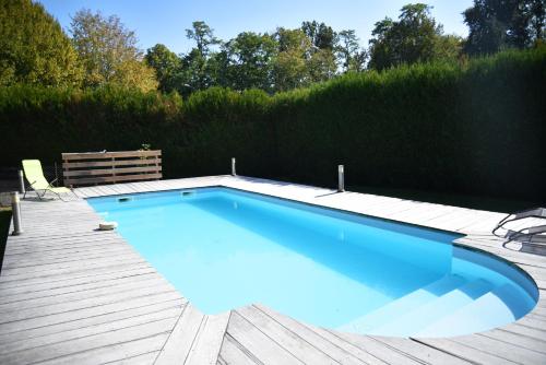 a large blue swimming pool on a wooden deck at Heartwood in Arbonne
