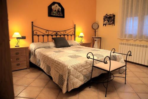 a bedroom with a large bed and two chairs at Cal Carreró in Claravalls