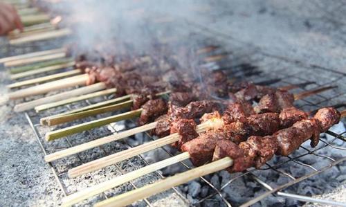 a group of skewers cooking food on a grill at Nizwa Park House Apartment in Nizwa