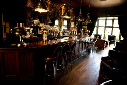 un bar con taburetes en una habitación en Mitton Hall Hotel, en Clitheroe