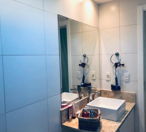 a bathroom with two sinks and a mirror at Iberostate Ilha do Mediterrâneo in Mata de Sao Joao