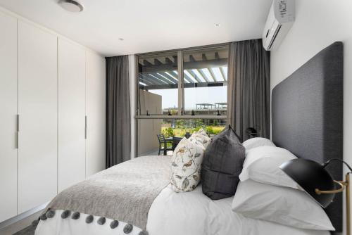 a bedroom with a large bed and a large window at Pebble Beach 128 Umdloti Durban in Umdloti