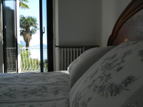 a bedroom with a bed with a view of a palm tree at Ca' d'Alfonso in Baveno