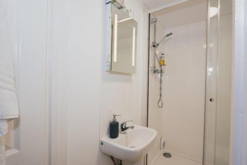 a white bathroom with a sink and a shower at River Court Apartments by Paymán Club in Cambridge