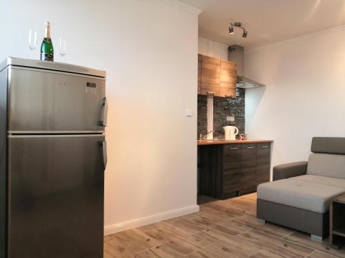 a kitchen with a stainless steel refrigerator and a couch at Vehlovice Apartments in Mělník