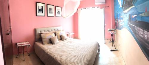 - une chambre avec un lit dans un mur rose dans l'établissement Appartement El Bahia Saidia destiné uniquement aux couple mariés, célibataires s'abstenir, à Saïdia