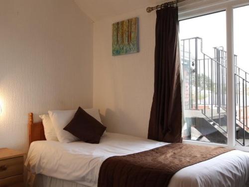 sypialnia z łóżkiem i oknem z balkonem w obiekcie Aberthaw House Hotel w mieście Barry