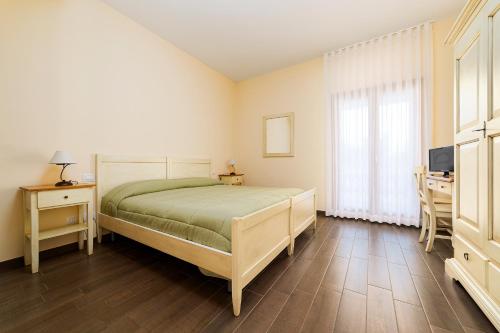 a bedroom with a bed and a desk and a television at Tenuta Gurgo in Bitonto