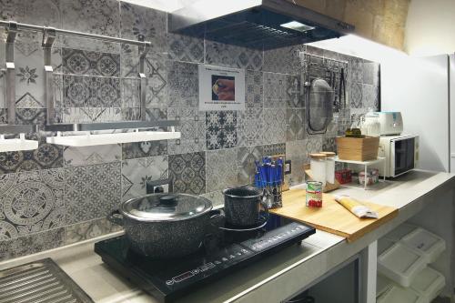 a kitchen with a counter with a pot on a stove at Ostello dei Sassi - Matera Hostels in Matera