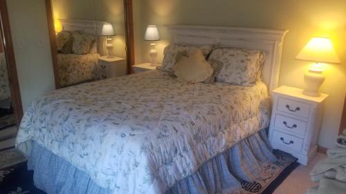 Schlafzimmer mit einem weißen Bett und einem großen Spiegel in der Unterkunft Cold Moon Farm B&B in Jamaica