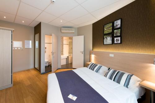 a bedroom with a large bed in a room at Hôtel de l'Univers Liège in Liège