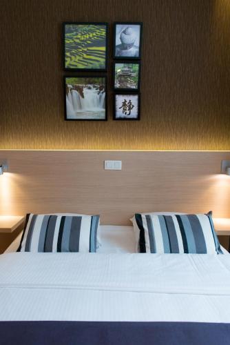 a bedroom with a bed with three pictures on the wall at Hôtel de l'Univers Liège in Liège