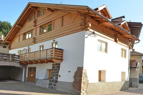 a house with a wooden roof and a balcony at Casa Seler - Appartamento rosso in Predazzo