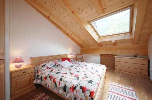 um quarto com uma cama e uma janela em Casa Seler - Appartamento rosso em Predazzo
