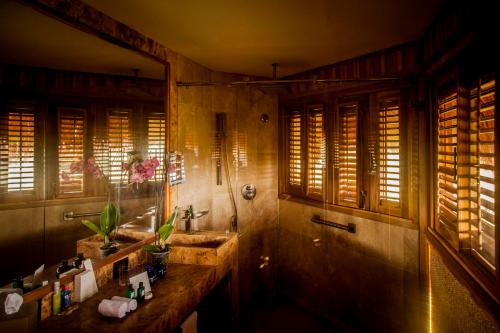 a bathroom with two sinks and a shower with windows at Hotel Las Islas in Barú