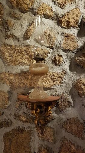 a light hanging on a stone wall at CASA DO CASTELLO MONSANTO in Monsanto