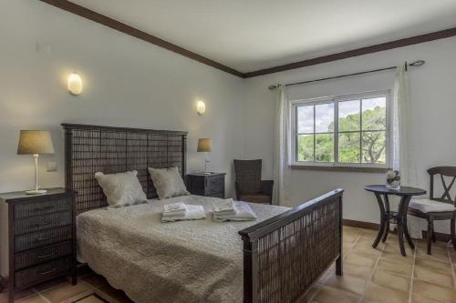 1 dormitorio con 1 cama grande y toallas. en Seaview Terrace Benagil Villa 45, en Benagil