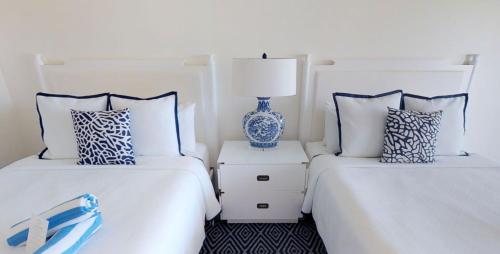 two white beds with blue and white pillows at Oceans Edge Key West in Key West