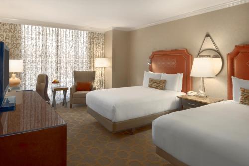 a hotel room with two beds and a chair at Fairmont Dallas in Dallas