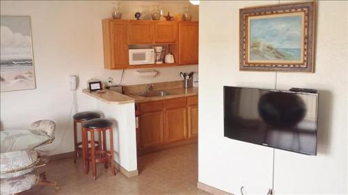a kitchen with a large flat screen tv on a wall at La Internacional Condos O211 in South Padre Island