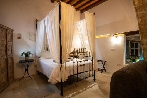 a bedroom with a bed with a canopy at Apanemia Inn Studio in Lofou