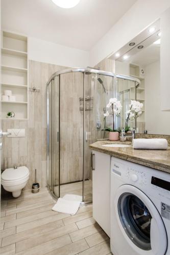 a bathroom with a washing machine and a shower at Grand Budapest Apartments in Budapest