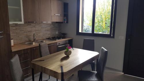 a kitchen with a wooden table with chairs and a sink at Case Vacanza Tony in Calatabiano