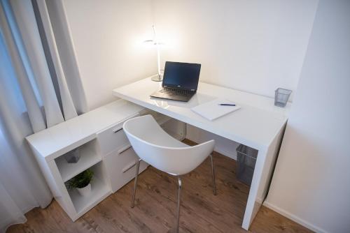 a white desk with a laptop and a chair at MH Living - 11 - Modern Living Dream in Center in Graz