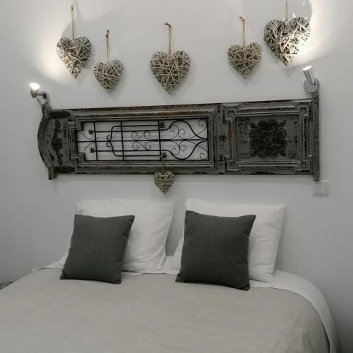 a bedroom with a bed with hearts on the wall at Casinhas do Canário in Montoito