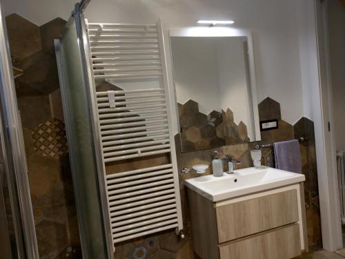 a bathroom with a sink and a shower with a mirror at Casa Mavì Limite delle due Matrici in Modica