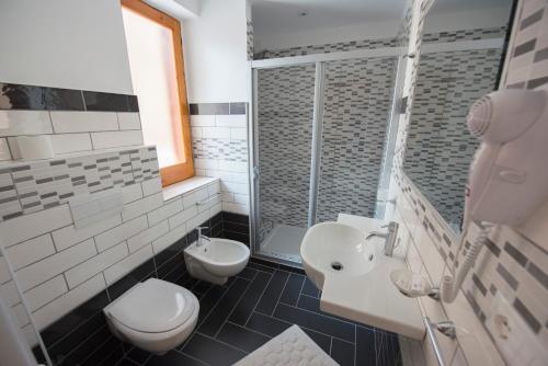 a white bathroom with a toilet and a sink at Donna Rosa Accommodation in Tropea