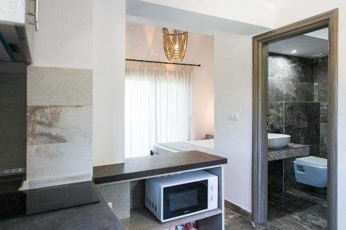 a bathroom with a television and a bathroom with a sink at Alexandros Hotel Apartments in Vourvourou