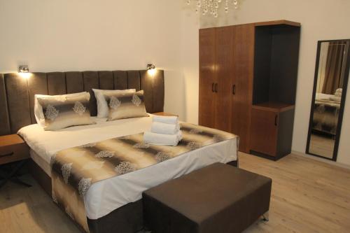 a bedroom with a large bed with a wooden headboard at Kispet Deluxe Hotels&Suites in Oberhausen