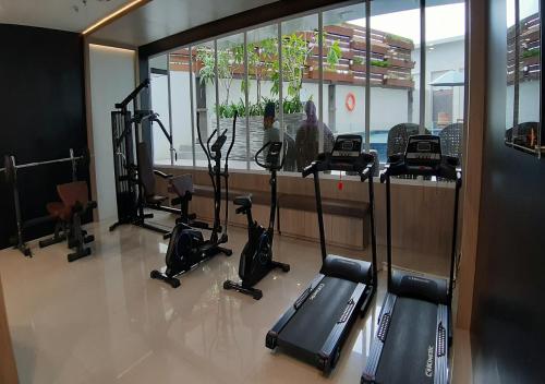 a gym with treadmills and exercise bikes in a room at Apartemen Taman Melati Yogyakarta by ArFe Room in Sleman