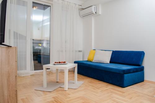 a living room with a blue couch and a table at Villa Re3ca in Skopje