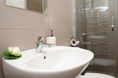 a bathroom with a white sink and a shower at Villa Re3ca in Skopje