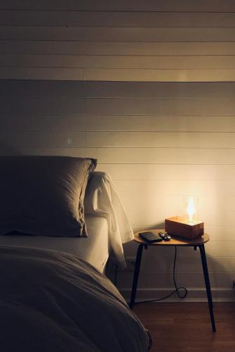 a candle on a table next to a bed at La Maison d'Ange in Le Hohwald