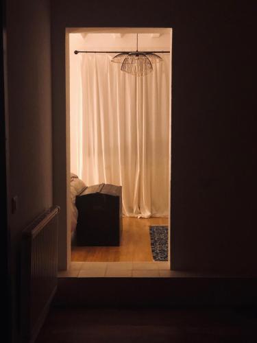 a door into a room with a window with a chandelier at La Maison d'Ange in Le Hohwald