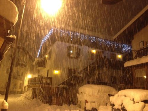 Une tempête de neige dans une maison avec une lumière dans l'établissement casa claudio-APPARTAMENTI IN CENTRO, à Campitello di Fassa