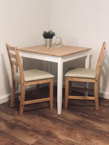 a table with two chairs and a table with a plant on it at La Maison d'Ange in Le Hohwald