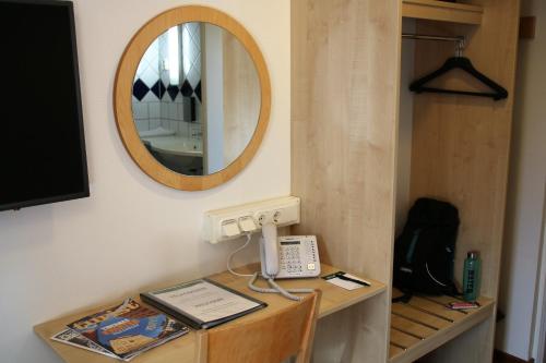 a mirror and a phone on a table in a room at Linköpings Cityhotell och Vandrarhem in Linköping