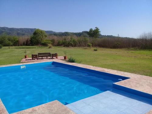 una piscina azul con un banco en un campo en Finca La Vertiente en El Encón
