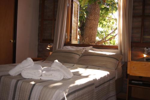a bed with towels on it in front of a window at Lorelei in Mina Clavero