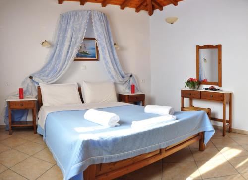 1 dormitorio con 1 cama azul con dosel en Anatoli Villa, en Steni Vala Alonissos