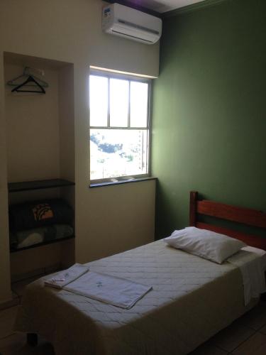 a bedroom with a bed and a window at HOTEL CENTRAL in Juruaia