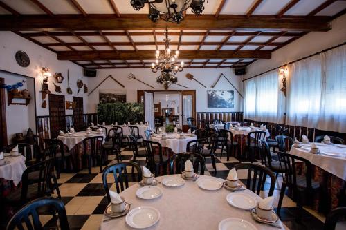 une salle à manger avec des tables et des chaises ainsi qu'un lustre dans l'établissement Hotel Los Perales, à Puebla de Sanabria